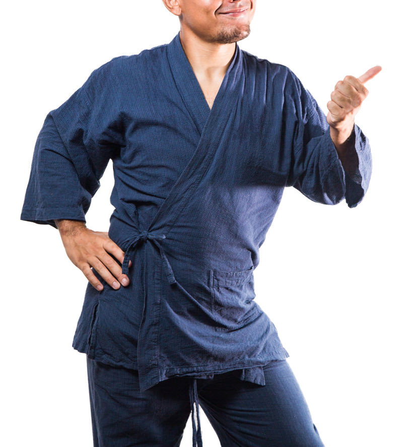 紺色の柔道着を着た男性が親指を立てていいねサインをしている