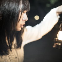 ランタンを持って暗闇で逃亡者を探す女性の不気味な姿の写真
