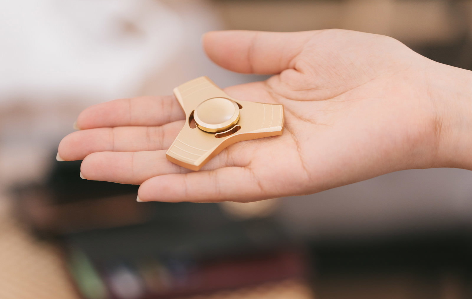 手のひらに金色のハンドスピナーを乗せている様子