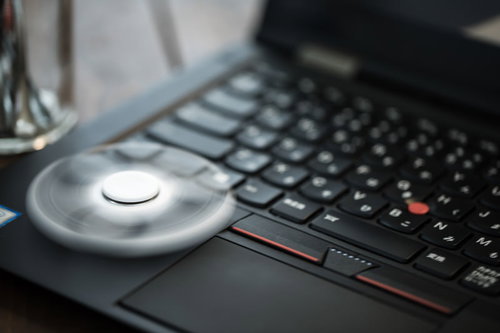 エンジニアのデスク上、ハンドスピナーとキーボード