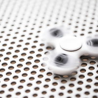 高速回転するハンドスピナー（シャッタースピード1/80）の写真