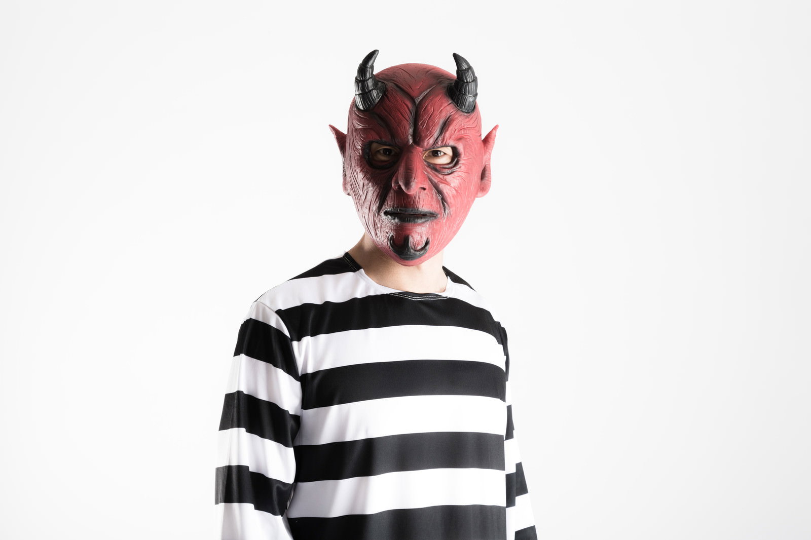 赤い悪魔マスクと囚人服姿の男性［モデル：大川竜弥］