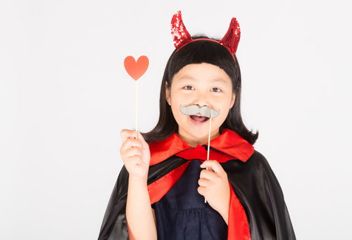 ハロウィン大好きな笑顔の少女がハート小物で遊ぶ