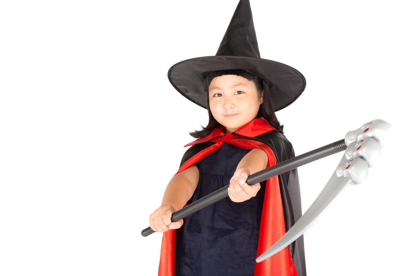 とんがり帽子と赤いマントで鎌を持つハロウィン仮装の少女［モデル：ゆうき］