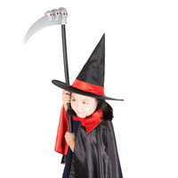 ハロウィン仮装で魔法使いの鎌を振り回すとんがり帽子の少女の写真
