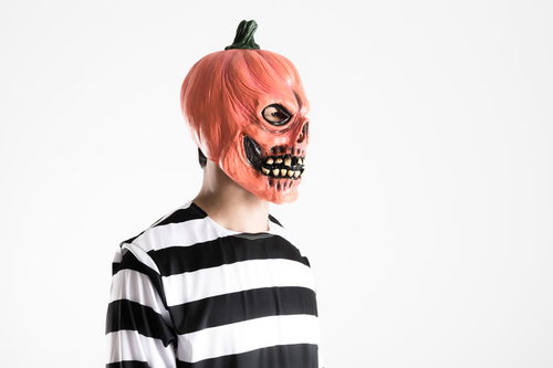 ハロウィンパーティーの会場を間違え呆然とするかぼちゃ頭の男性