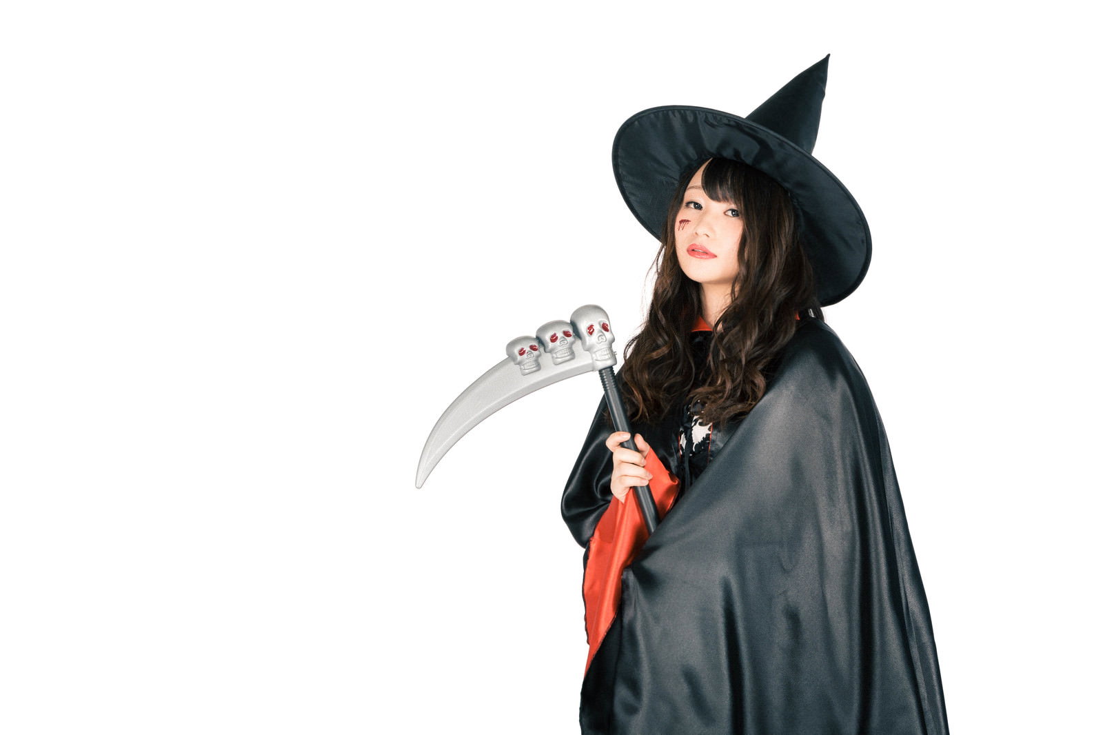 黒い帽子と赤黒衣装で鎌を持つ魔法使いコスプレ女性［モデル：茜さや］