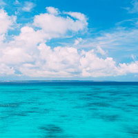 大きな白い積乱雲と宮古ブルーの海の水平線風景の写真