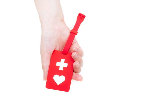 赤いヘルプマークを持った手