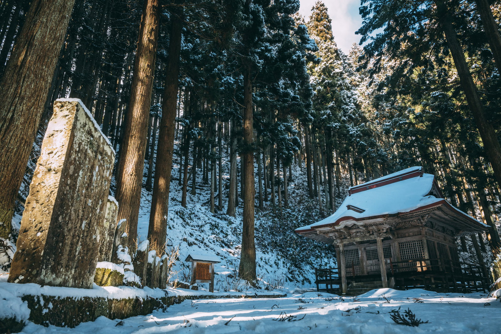 A stone Kannon hall standing in a snow-covered compound