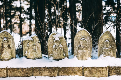 雪をかぶる一列のお地蔵さん