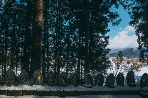 積雪の杉林に一列で並ぶお地蔵様・福島県郡山市