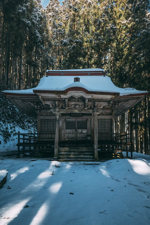 雪の観音堂から伸びる影 福島県郡山市の冬の寺院風景