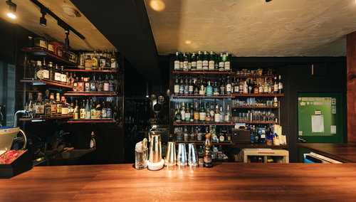 カウンター奥に多種多様なお酒が並んだバー店内