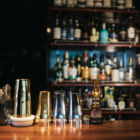 金銀大小のシェイカーが並ぶバーのカウンターの写真