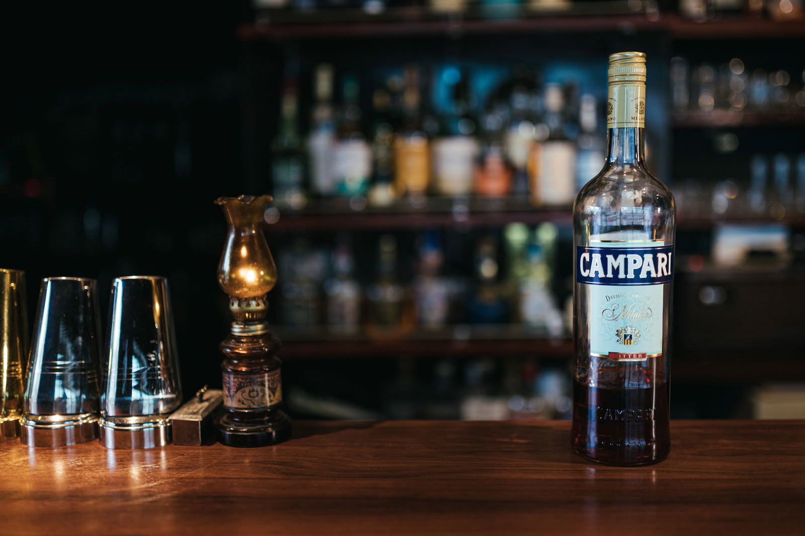 木製のバーカウンターに置かれたカンパリのボトル