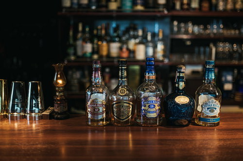 シーバスリーガルなどのウイスキーボトルとバーカウンター