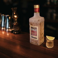 冷凍したテキーラ オルメカゴールドのショットグラスとバーカウンターの写真