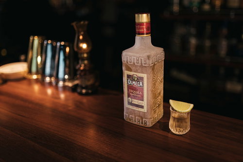 冷凍したテキーラ オルメカゴールドのショットグラスとバーカウンター
