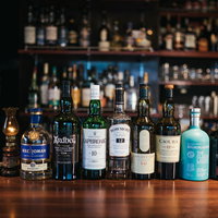 アイラモルトやシングルモルトなど多くの銘柄が並ぶバーカウンターの写真