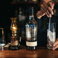 ロンサカパのソーダ割りのビルド、 バースプーンを使ってグラスを冷やすバーテンダーの写真