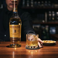 グレンモーレンジのウイスキーをバーカウンターで提供するバーテンダーの写真