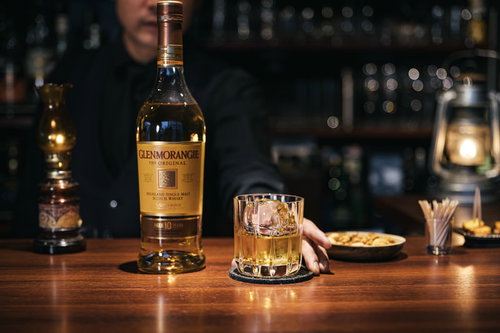グレンモーレンジのウイスキーをバーカウンターで提供するバーテンダー