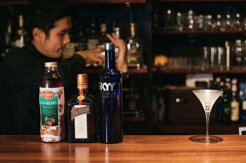 コスモポリタンカクテルをシェークするバーテンダー