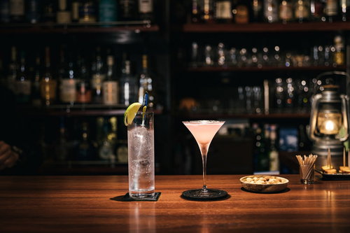 バーカウンターに並ぶジントニックとコスモポリタンカクテル