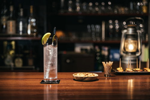 バーカウンターに置かれたオレンジ飾りのジントニック