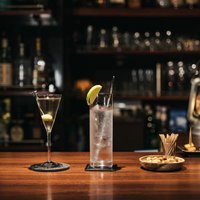 バーカウンターに並ぶマティーニとジントニックの写真