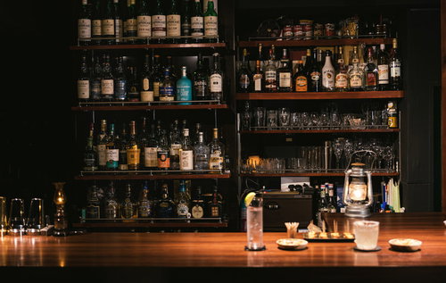 二人分のカクテルやおつまみが並んだおしゃれなバーのカウンターの様子