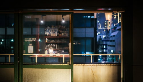 オフィス街の夜景を眺めるバーのカウンター