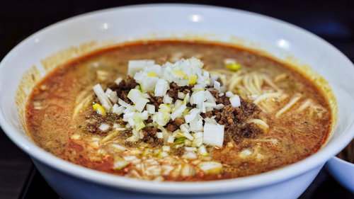 赤いスープが特徴の刻みネギが乗った担々麺