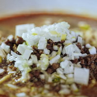 刻みネギとひき肉がたっぷりの担々麺、激辛スープ仕立ての一杯の写真
