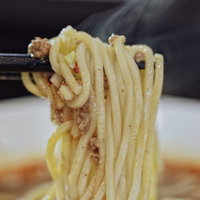 熱々のもっちり麺に汁がよく絡む箸で持ち上げたラーメンの写真