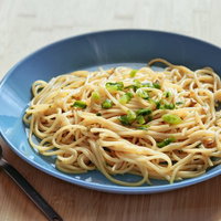 青い皿に盛られたシンプルな和風パスタとフォークの写真