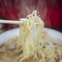 箸で持ち上げたもやしが絡まる熱々のタンメンの写真