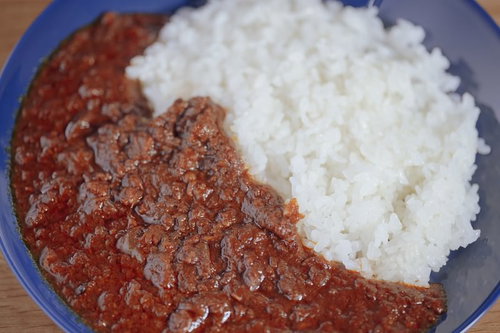 青いお皿に盛られたひき肉カレーとライス、玉ねぎトッピング