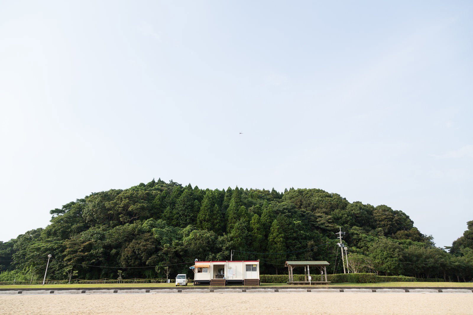 イマリンビーチの砂浜と白い建物と丘
