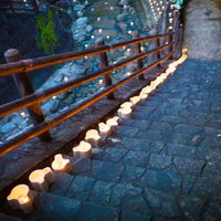 夜間の石段階段に一列に置かれた白い灯ろうのライトアップ風景の写真