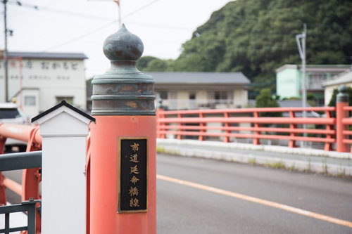 伊万里市の市道延命橋線、赤い橋と緑の山並み