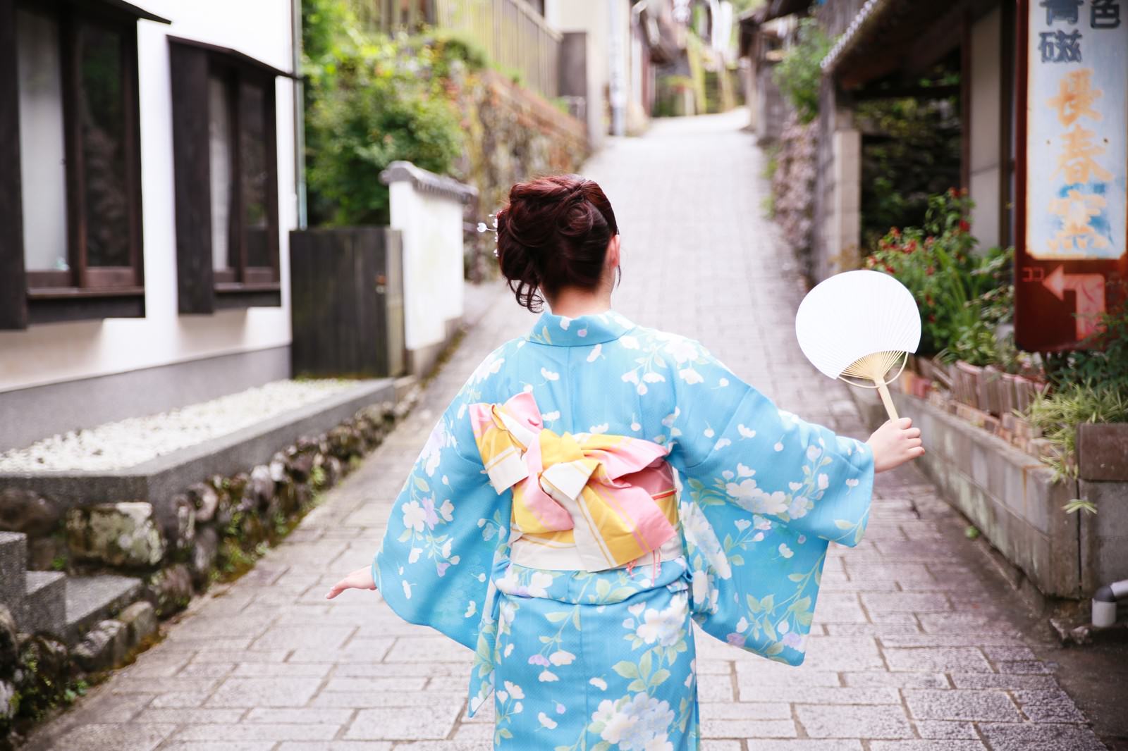 石畳の坂道を歩く浴衣姿の女性の後ろ姿［モデル：河村友歌］