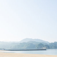 静かな人工海浜公園「イマリンビーチ」の砂浜と防波堤の写真