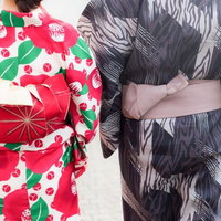 浴衣姿のカップルが並んで歩く後ろ姿、夏祭りデートの写真