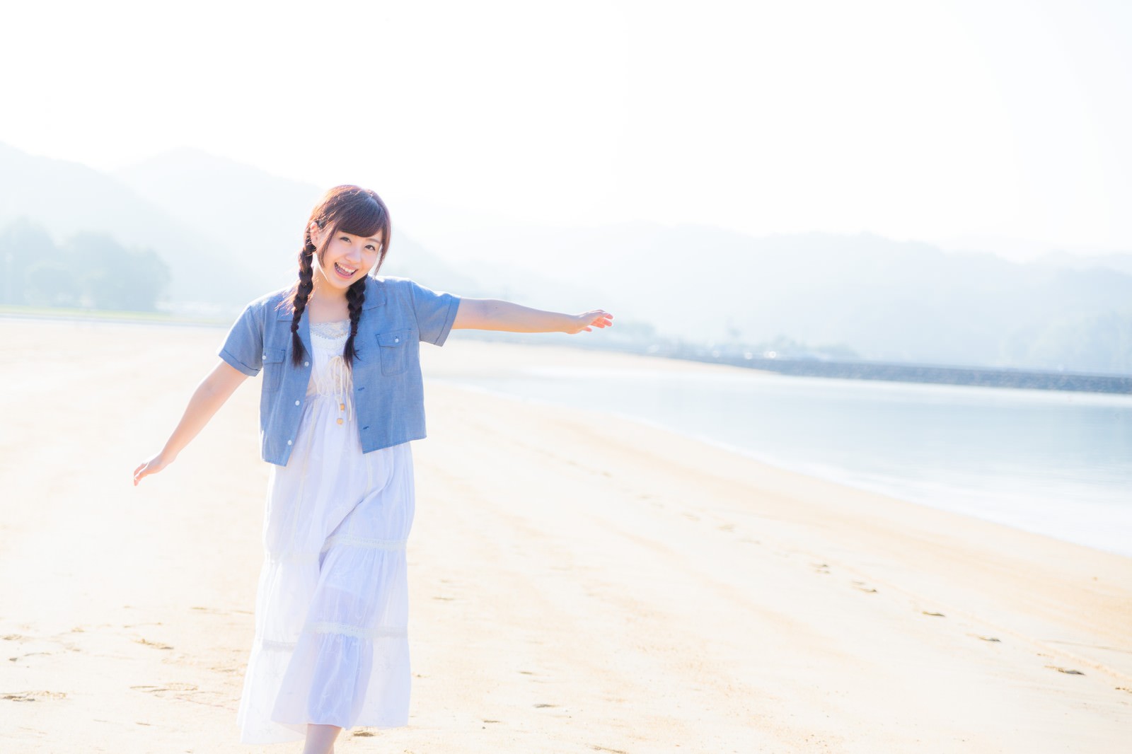イマリンビーチで両腕を広げる女性［モデル：河村友歌］