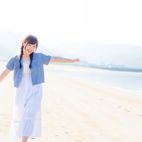 イマリンビーチで両腕を広げて笑顔の女性の写真