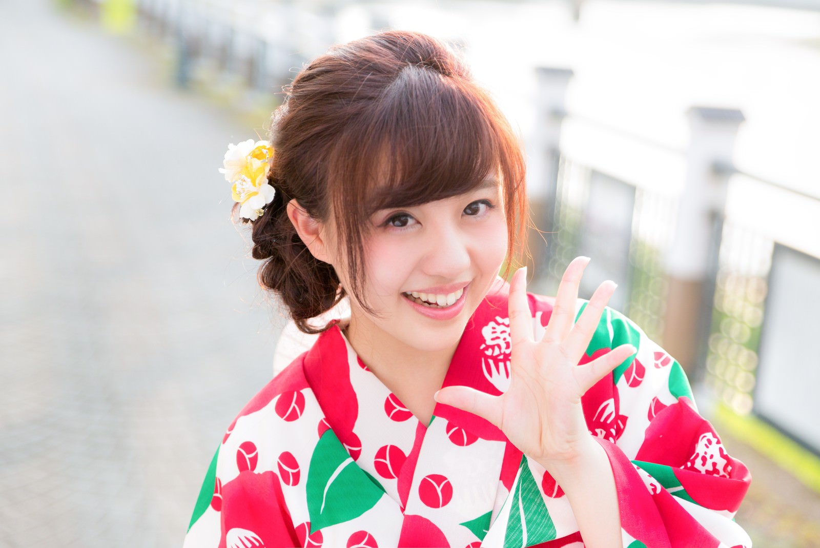 花柄浴衣で手を振る笑顔の女性［モデル：河村友歌］