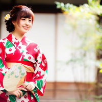 赤い花模様の浴衣姿でお出迎え、夏祭りの風情を演出の写真