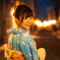 夜間の街並みで振り返る浴衣姿の女性、祭りデート帰り道の写真